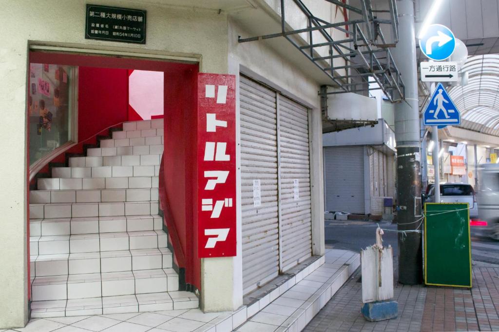 a building with a red and white sign on it at Little Asia Guest House in Naha