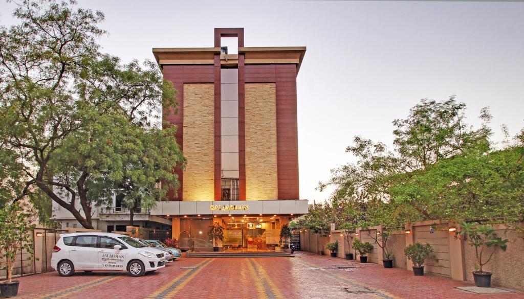 un coche aparcado frente a un edificio en Hotel Sai Jashan, en Shirdi