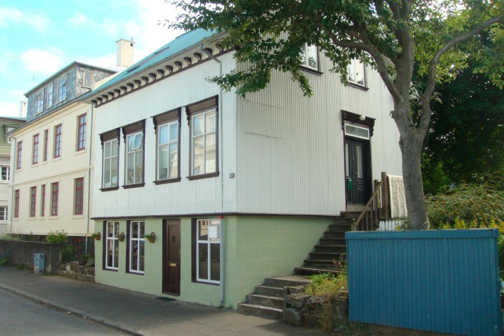 una casa bianca con un albero davanti di Ranargata Apartment a Reykjavik