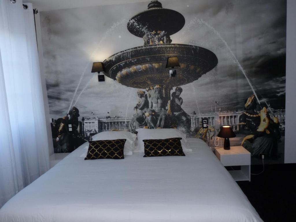 a hotel room with a large bed and lamps at Hôtel Patton in Avranches