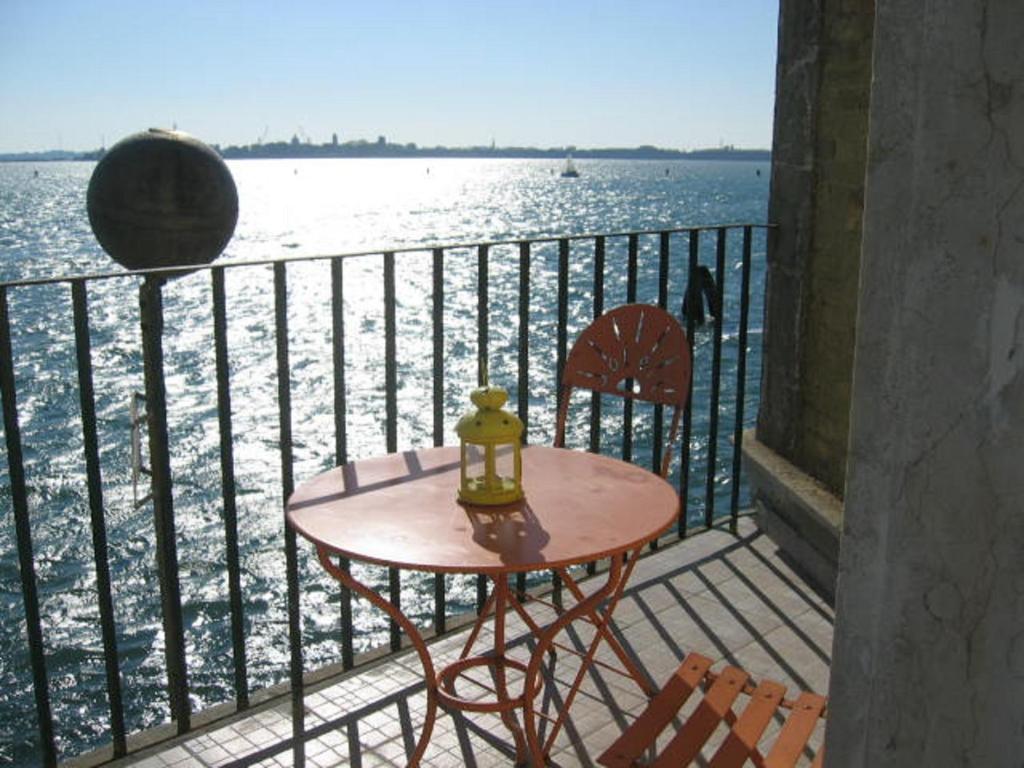 a table and chairs on a balcony overlooking the water at Casa Sulla Laguna in Murano