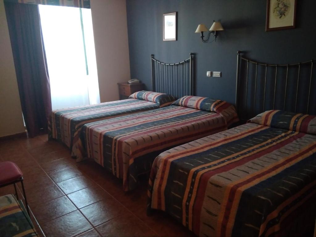 Postel nebo postele na pokoji v ubytování Hotel Alonso de Monroy