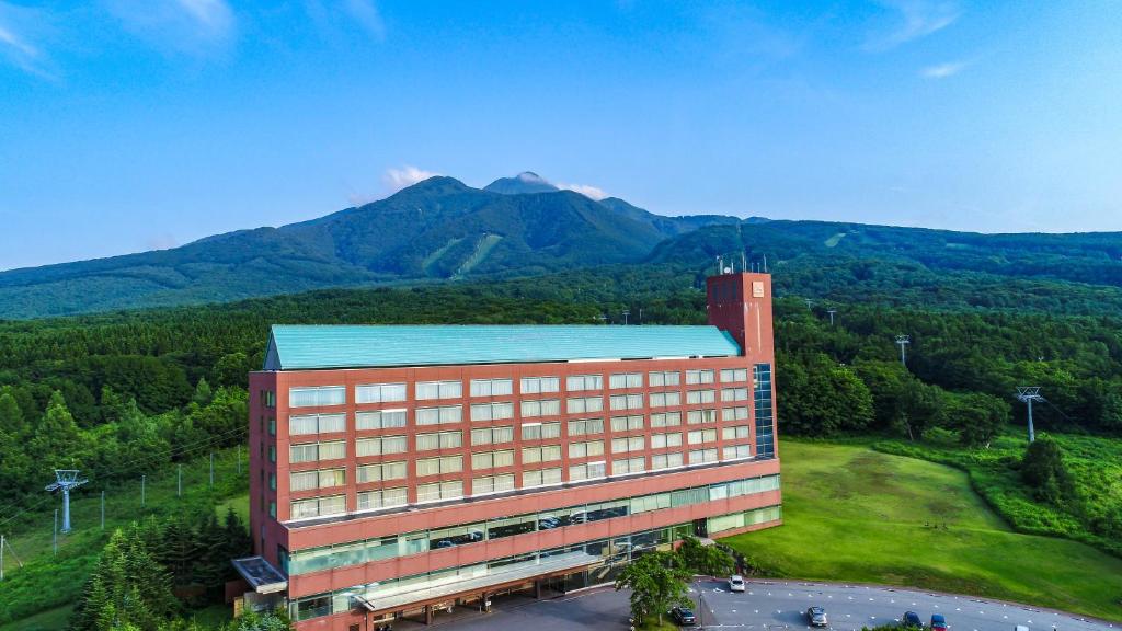 Rockwood Hotel & Spa في Ajigasawa: اطلالة علوية على مبنى فيه جبال في الخلفية