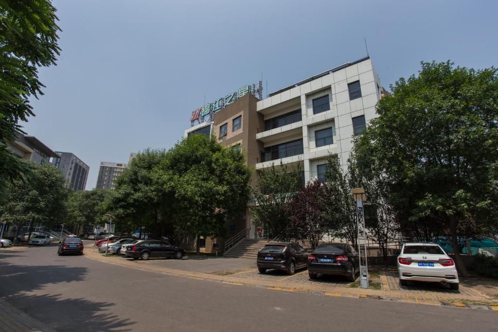 een straat met auto's geparkeerd voor een gebouw bij Jingjiang Inn Beijing Yizhuang Development Zone in Daxing