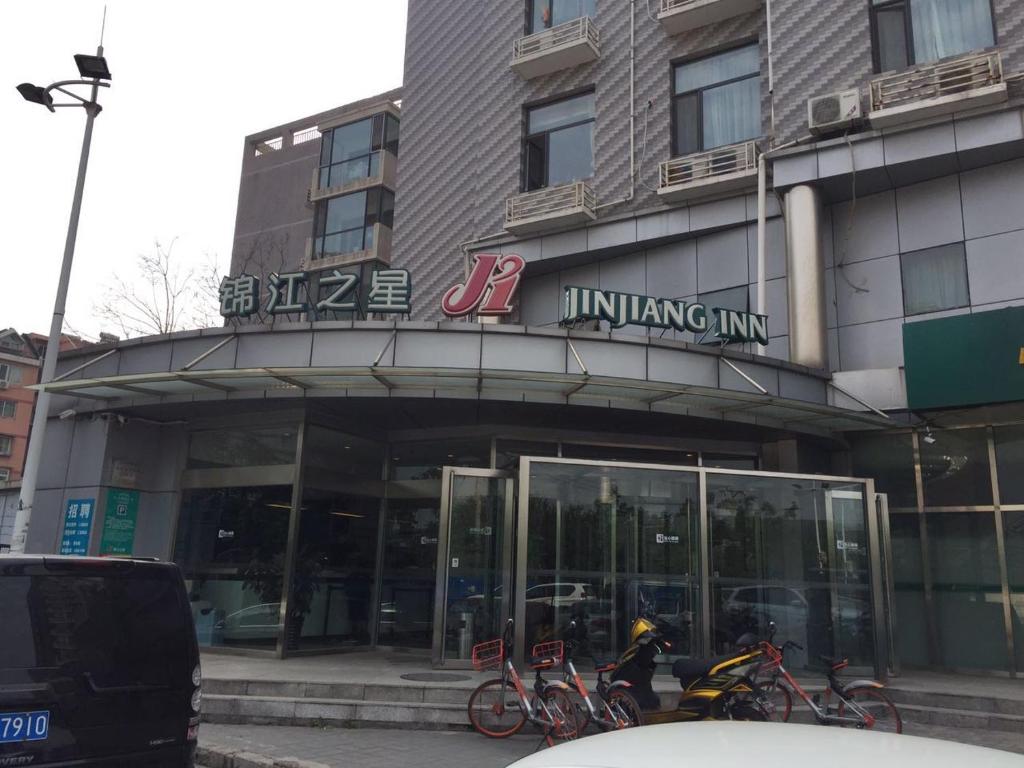 ein Gebäude mit Fahrrädern, die davor geparkt sind in der Unterkunft Jinjiang Inn Beijing Pingguoyuan in Peking