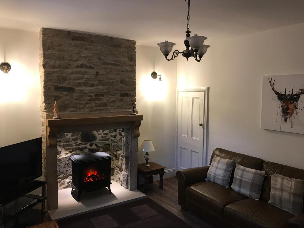 a living room with a fireplace and a couch at The Dales in Stanhope