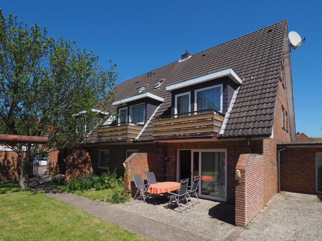 a house with a table and chairs in the yard at Apartmenthaus Jasmin in Büsum