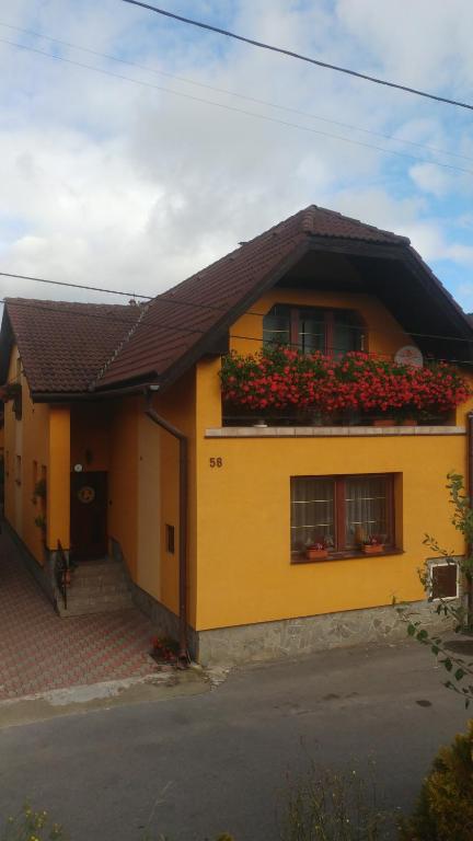 a yellow house with flower boxes on the roof at Privát u Zdenky in Tvrdošín