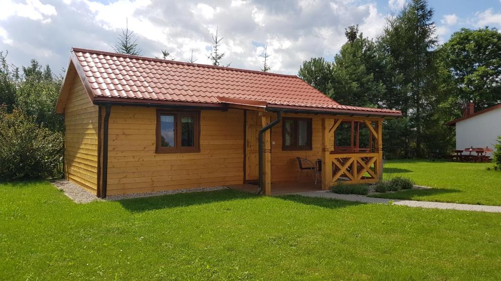 ギジツコにあるGościniec Mazurek , Domek drewniany 1の赤い屋根の小さな木造キャビン