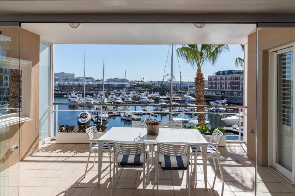 a balcony with a table and chairs and a view of a harbor at Atlantic Marina in Cape Town