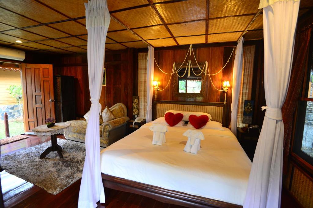 a bedroom with a bed with two pillows on it at Viang Yonok Hotel, Restaurant, Sports Club in Chiang Saen