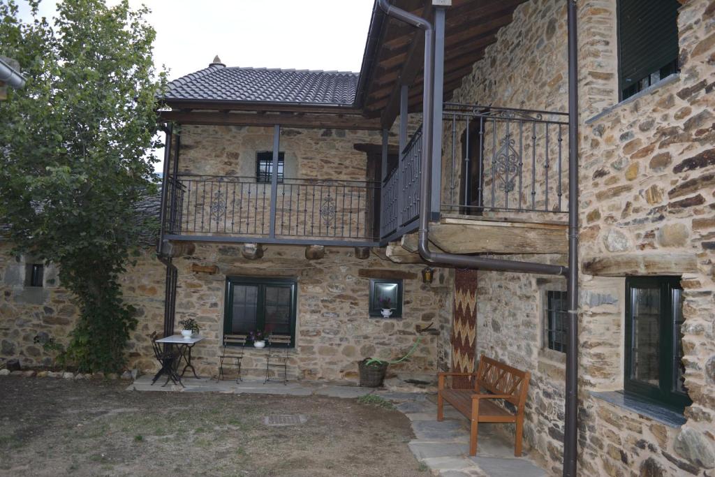 a stone building with a balcony and a bench at La Casa de Rosa in Filiel