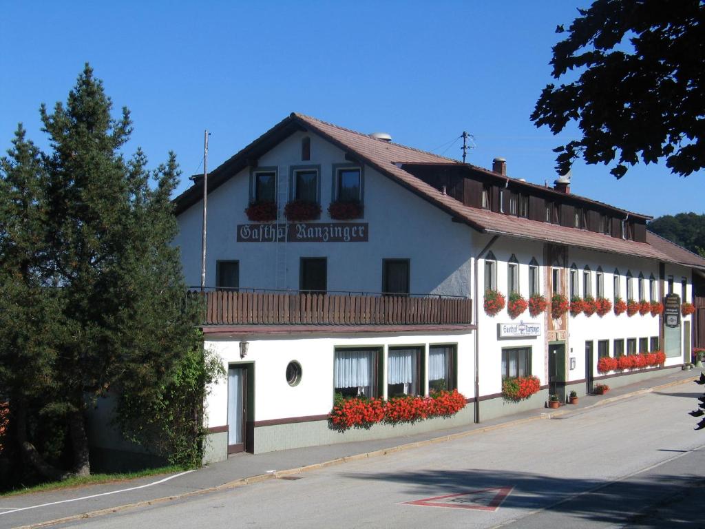 ein weißes Gebäude mit einem Schild, das die Verankerung der Grafschaft angibt in der Unterkunft Panorama-Landgasthof Ranzinger in Schöfweg