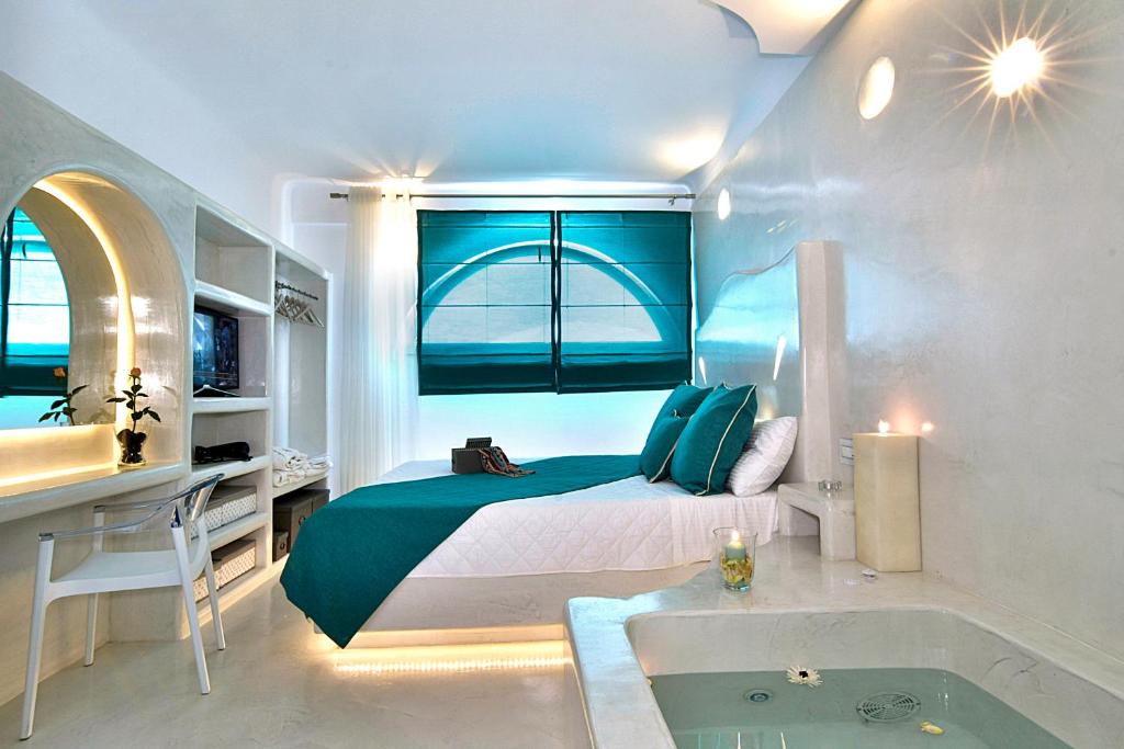 カマリにあるSantorini Loftのベッドルーム1室(バスタブ、窓付)