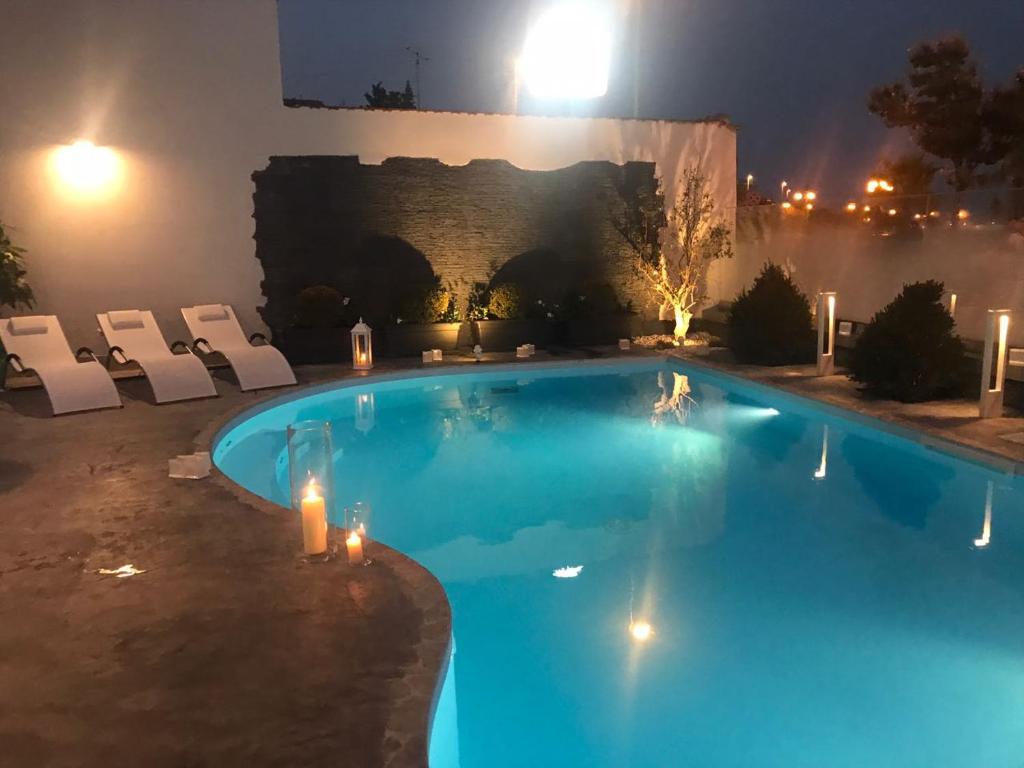 - une piscine avec des chaises et un bâtiment la nuit dans l'établissement Residence del sole Manfredonia, à Manfredonia