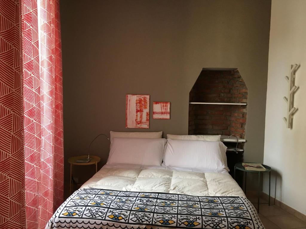 ミラノにあるMaison Lodiのレンガの壁、ベッド付きのベッドルーム1室