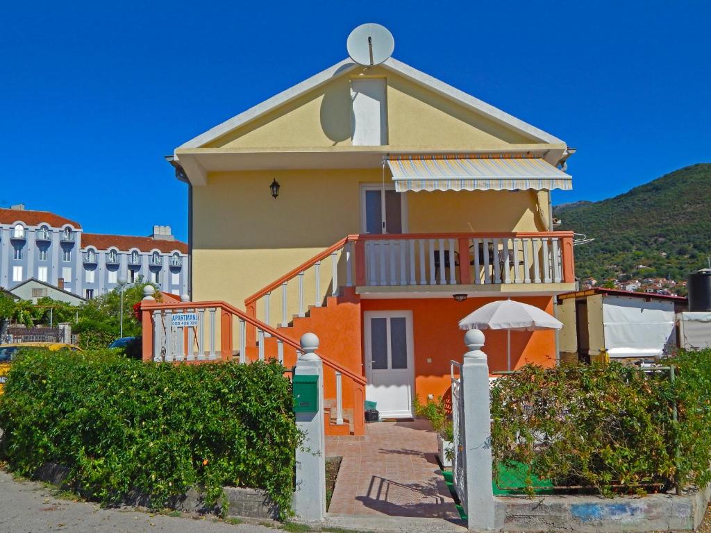 a house with an orange and yellow at Apartmani Sindik in Tivat