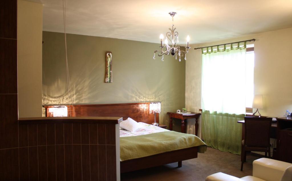 1 dormitorio con cama y lámpara de araña en Noclegi Nad Osławą, en Zagórz