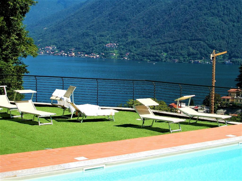 a group of chairs sitting next to a swimming pool at Green & Lake Home in Argegno