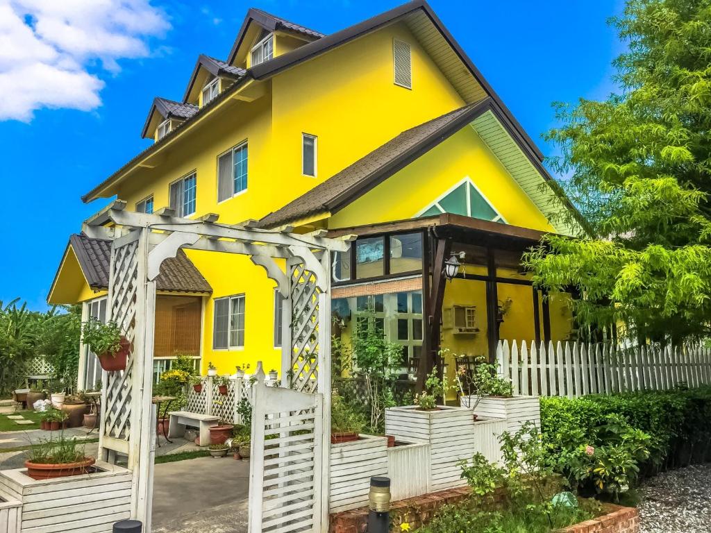 平和村的住宿－禾園悅舍民宿，白色围栏的黄色房子