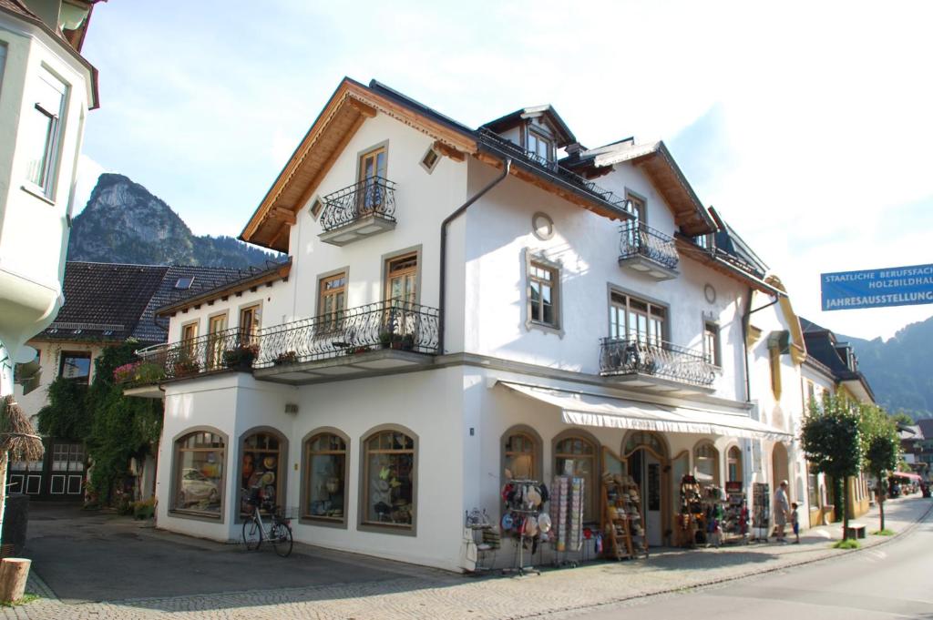 um edifício branco ao lado de uma rua em Kronburger em Oberammergau