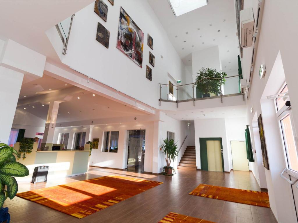 ウィーナー・ノイシュタットにあるWinrooms Seminar Hotel & Apartmentsの大きなラグが敷かれた広い客室です。