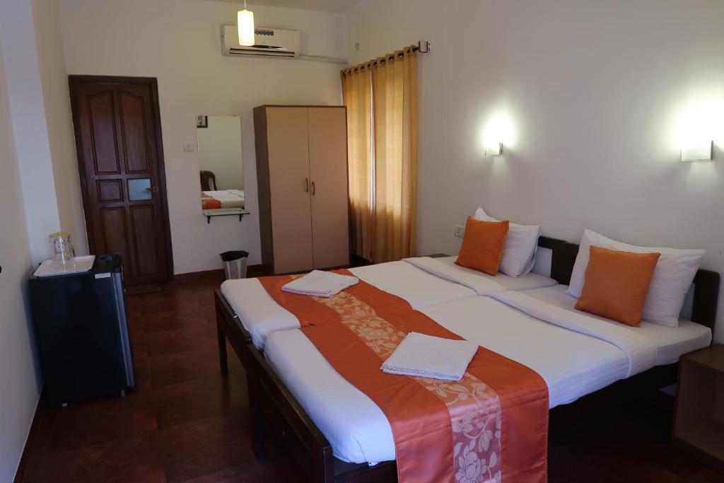 a hotel room with two beds and two lamps at Hotel Celi in Calangute