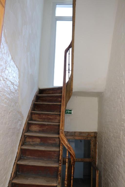 a wooden staircase in a room with a window at Mañana Mañana in Antwerp