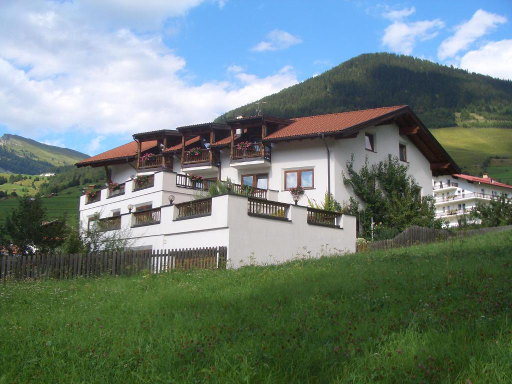a white building with balconies on the side of a hill at Ferienhaus Auer in Nauders