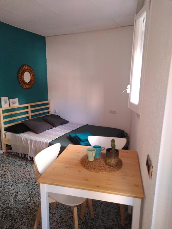 タラゴナにあるEstudio acogedorのテーブルとベッド付きの小さな部屋