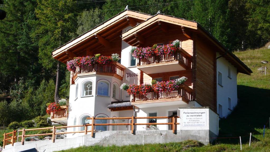 a building with flower boxes on the balconies at Haus Piccolo in Saas-Grund