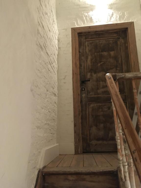 a staircase with a wooden door in a room at Mañana Mañana in Antwerp