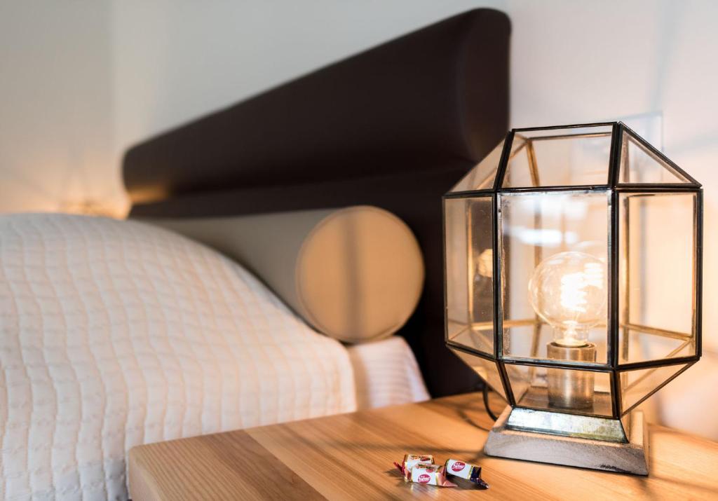 uma lanterna de vidro sobre uma mesa ao lado de uma cama em B&B Casin dei Nobili em Veneza
