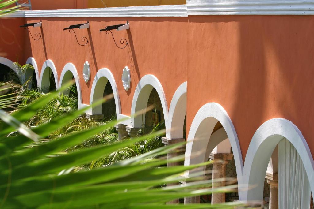 un bâtiment avec des arches blanches sur son côté dans l'établissement Hotel Hacienda Mérida, à Mérida