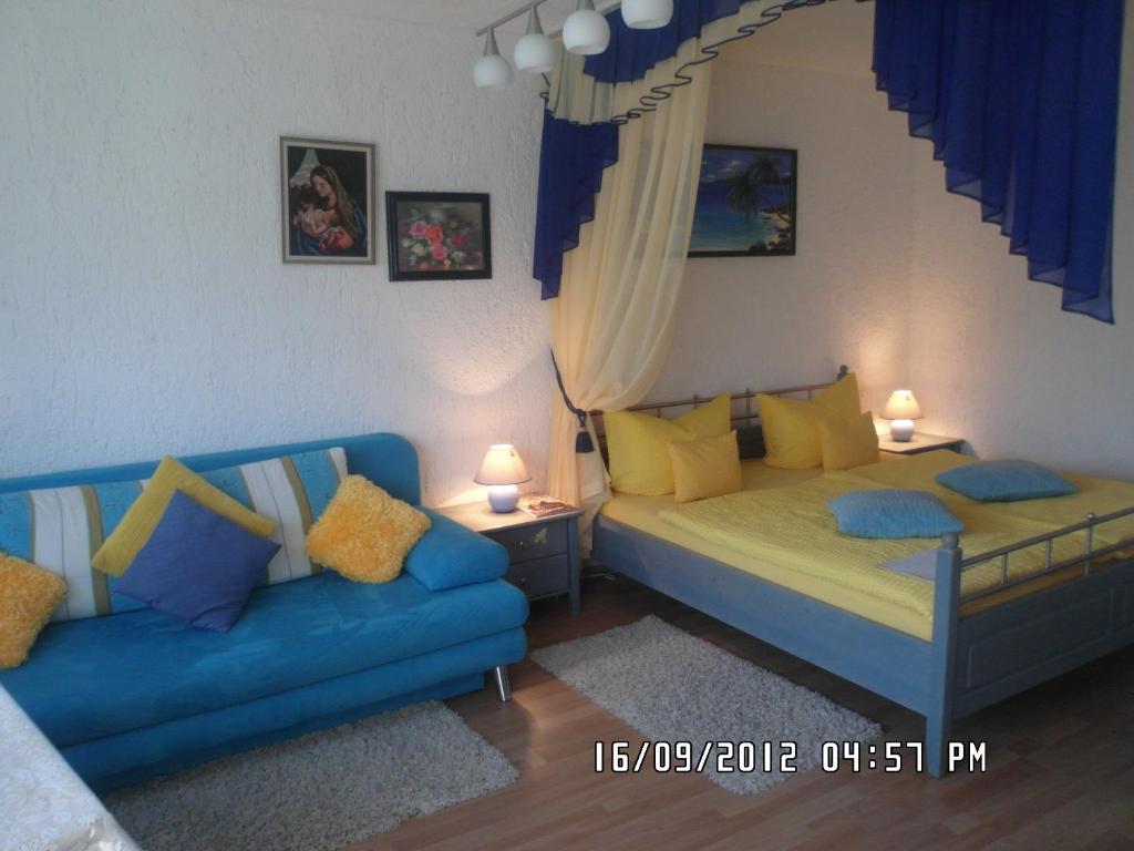 ein Schlafzimmer mit 2 Betten und einem blauen Sofa in der Unterkunft Appartement Sonnenhof in Füssen