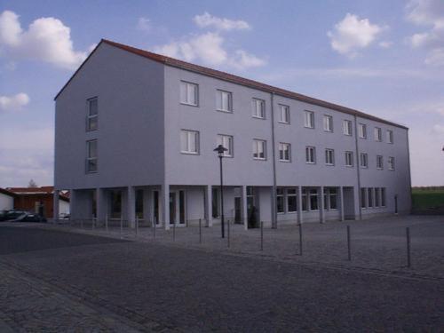 a large white building on the side of a street at Hotel am Platz in Hohenmölsen