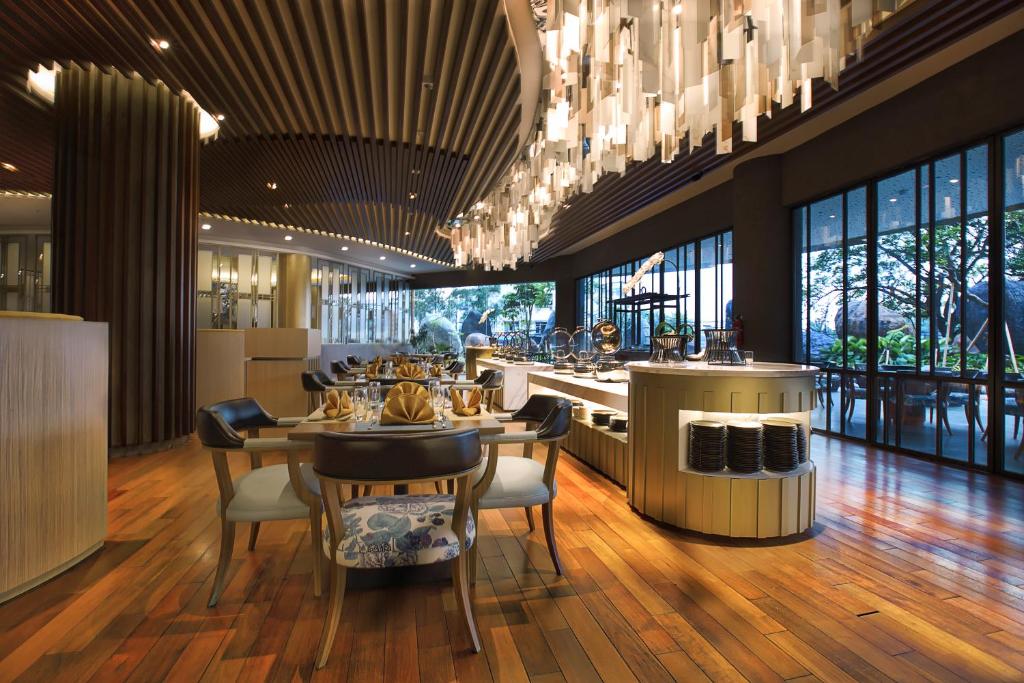 a restaurant with tables and chairs and a chandelier at Grand Soll Marina Hotel in Tangerang