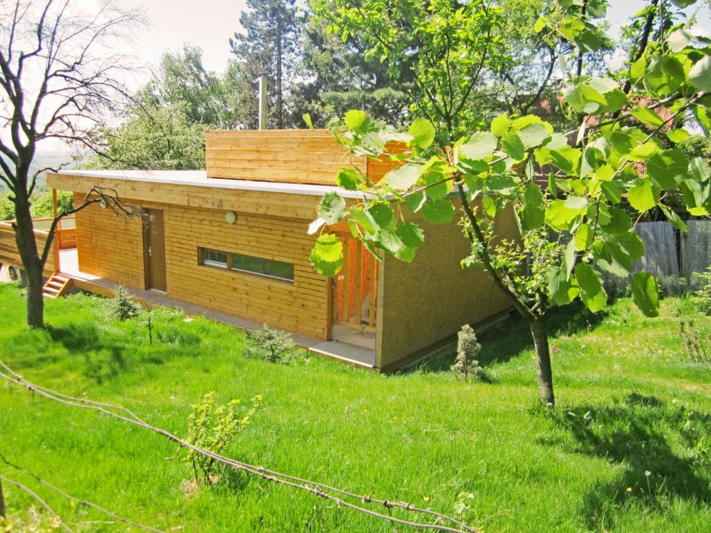 een klein huis in een tuin met een groen gazon bij Vacation Home Pani haje in Moravany