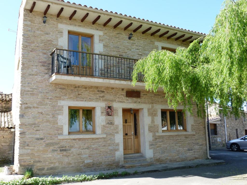 una casa con un balcón en el lateral. en Casa Rural La Fuente, en Trabanca