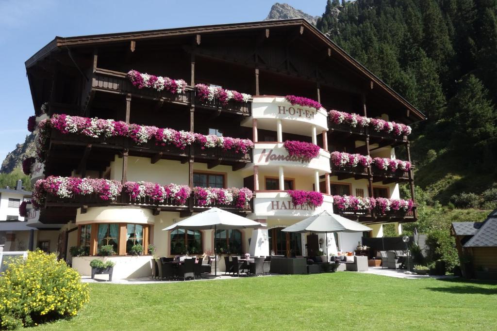 un hotel con flores a un lado en Verwöhn-Harmoniehotel Mandarfnerhof, en Sankt Leonhard im Pitztal