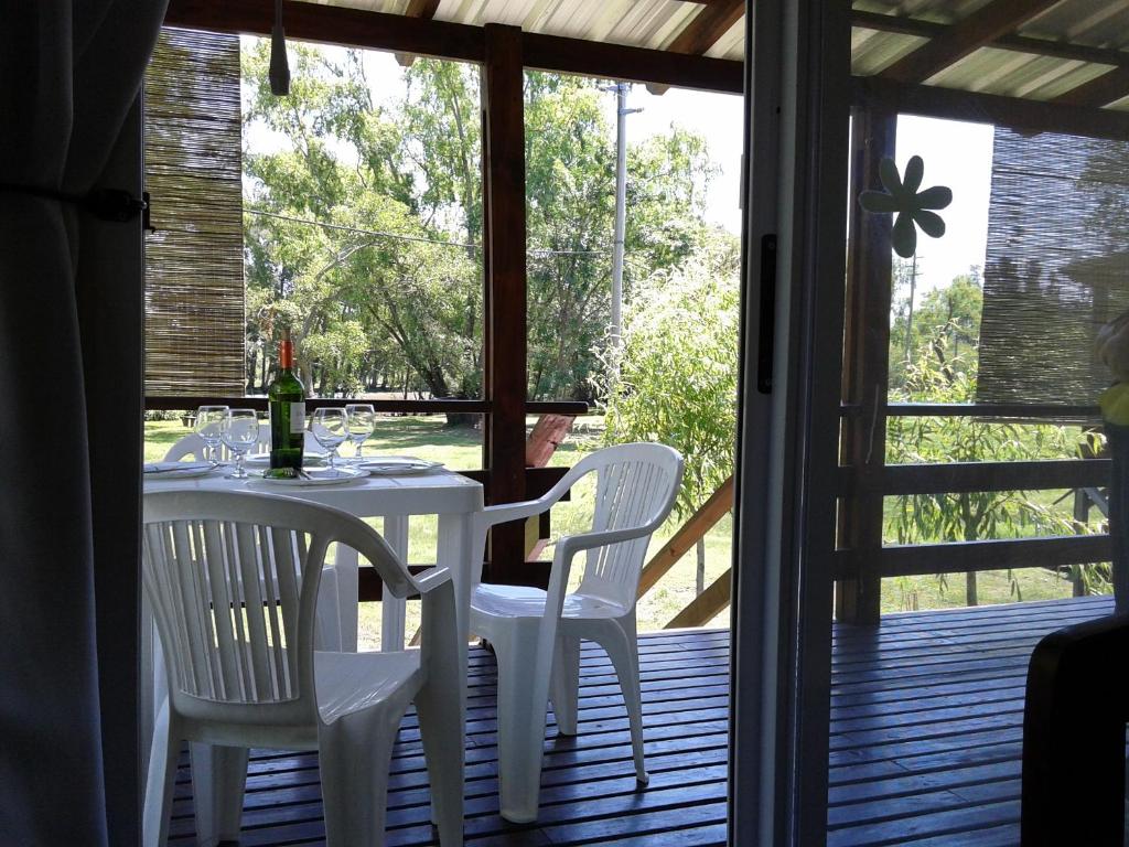 una mesa de comedor blanca y sillas en un porche en Cabañas Puerto Trinidad en Tigre