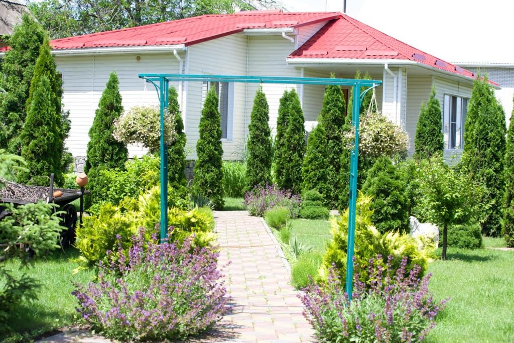 einen Garten mit einem Weg vor einem Haus in der Unterkunft Дом для Души с бассейном целиком in Winnyzja
