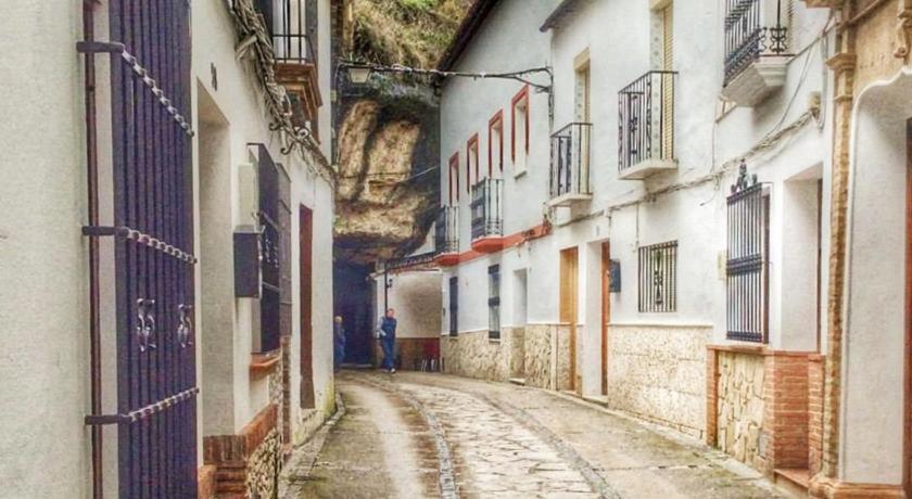 un hombre caminando por una calle en un callejón en Vivienda Rural Los Tajos de Setenil, en Setenil