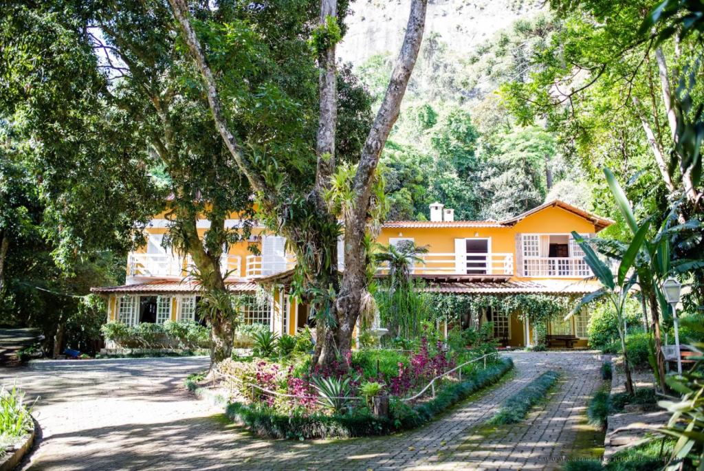 an orange house with a garden in front of it at Pousada Quinta da Jade in Itaipava