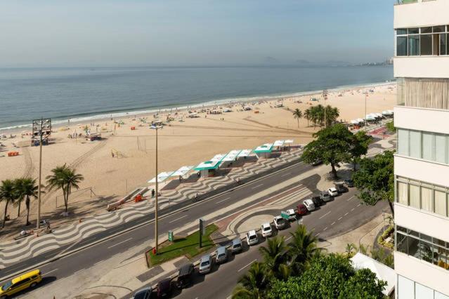una vista de una playa con coches estacionados al lado de un edificio en Copacabana Frente para a Praia 1005, en Río de Janeiro
