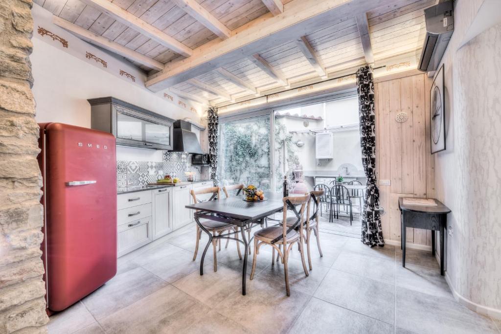 フィレンツェにあるジリオ アパートメンツのキッチン(赤い冷蔵庫、テーブル、椅子付)