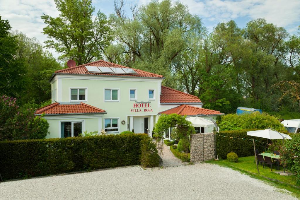 Casa blanca con techo rojo en Hotel Villa Rosa, en Allershausen