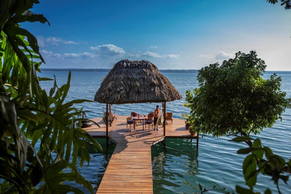 a dock with a table and chairs on the water at La Lancha in El Remate