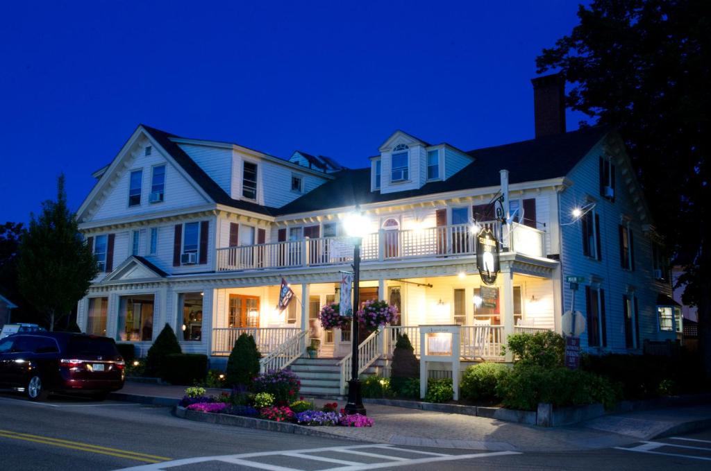 a large white house with a car parked in front of it at The Kennebunk Inn in Kennebunk