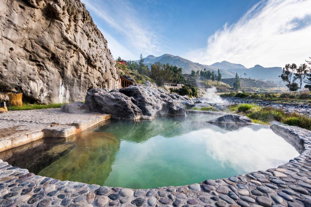 a hot spring in a canyon with green water at Colca Lodge Spa & Hot Springs in Yanque